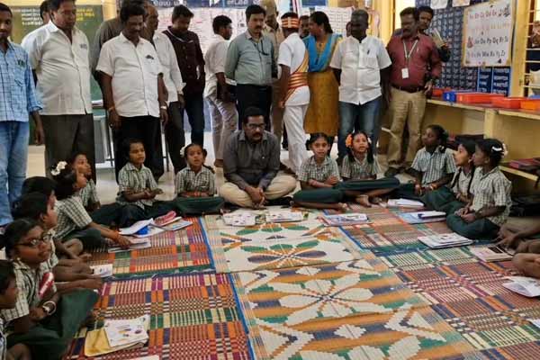 collector sat on the floor and ate the food with the school students