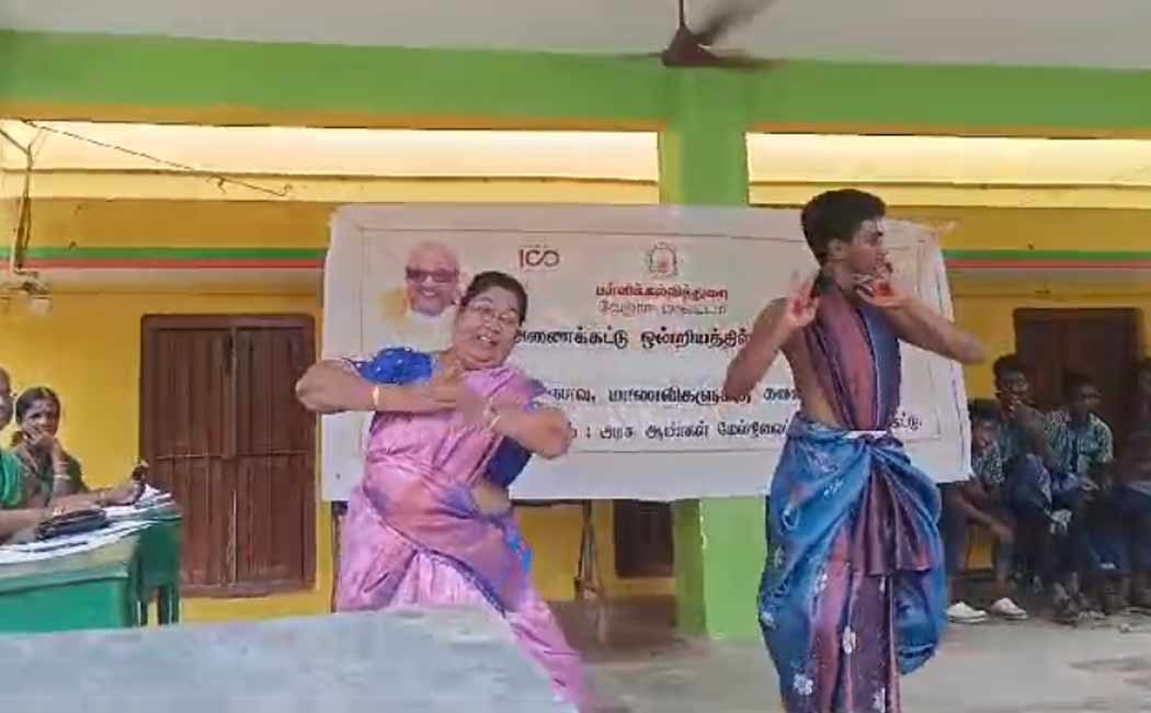 Tamil teacher dances with student at art show