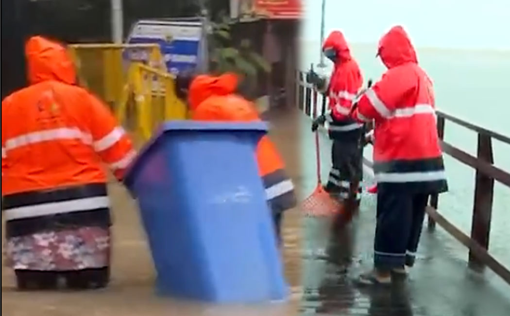 Sanitation workers doing their job despite the pouring rain