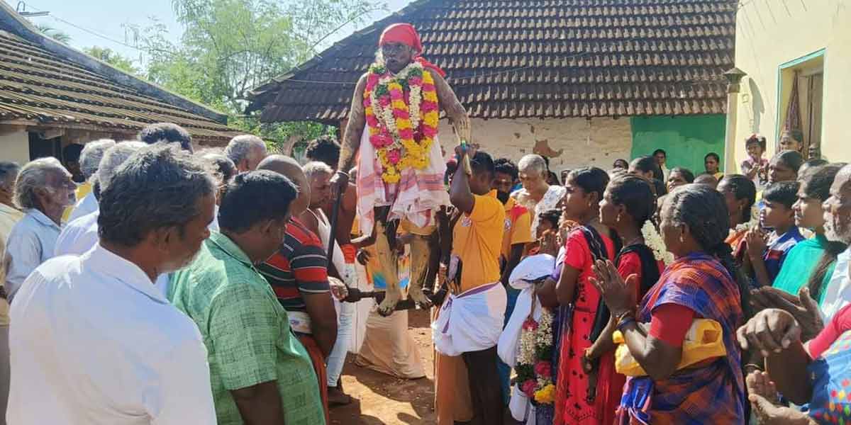 Arulvaku standing on a sickle-people tending to the neighboring village