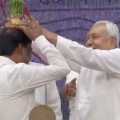 Nitish Kumar places a flower pot on the head of an IAS officer in bihar